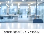 Blurred background of modern office with glass walls and a table in the foreground.