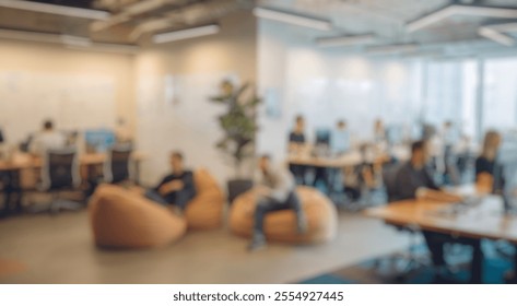 Blurred background of modern office space with creative work environment featuring bean bag chairs, collaborative workstations, and engaged employees in a bright, open atmosphere - Powered by Shutterstock