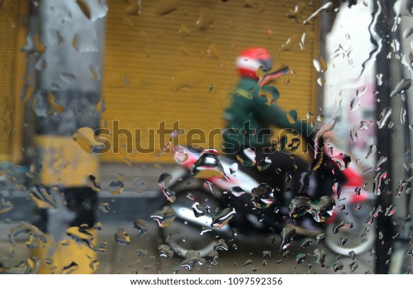 Blurred\
background of Motorcycle rides in the\
rain