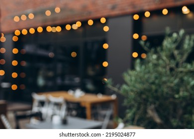 Blurred background of outdoor restaurant with abstract bokeh light. Outdoor cafe with tables and chairs - Powered by Shutterstock