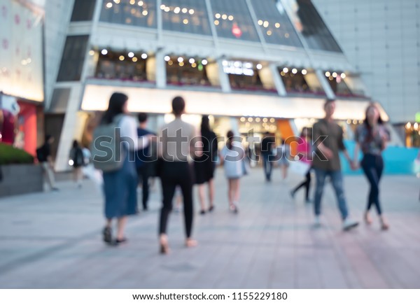 Blurred background of people crowd walking on\
pedestrian in front of department store in late afternoon, shopping\
centre in the city, Seoul, Korea, urban scene can be used for\
business background