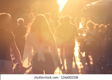 Blurred Background People Walking On Street With Sun Flare