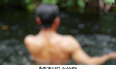 Blurred Background Photo Of The Man Is Bathing In The Clear River Water.