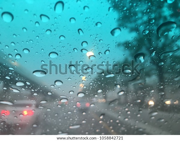 Blurred\
background, raindrop on the windshield, traffic in the city on a\
rainy day, car windshield view, colorful\
bokeh.