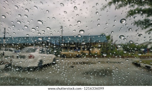 Blurred background, raindrops on\
the windshield, windshield view on a rainy day. Selective focus.\
