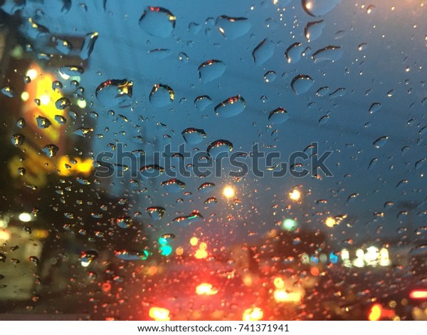 Blurred background,\
raindrops on the windshield, street lights at night on a rainy day,\
colorful bokeh.