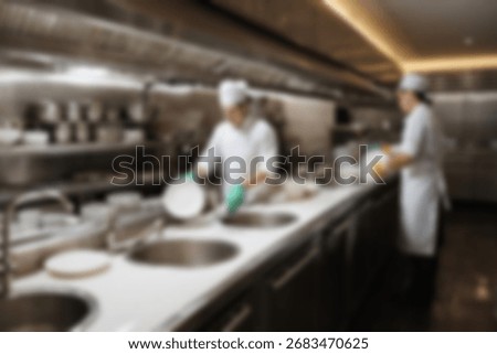 Blurred background a restaurant kitchen worker is working washing dishes after being used by customers.