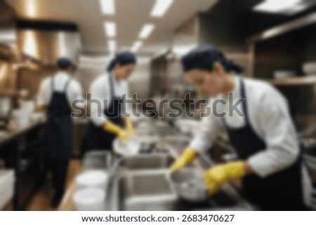 Blurred background a restaurant kitchen worker is working washing dishes after being used by customers.