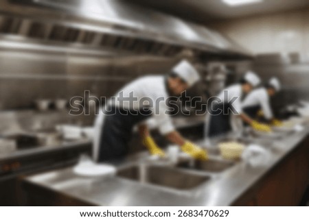 Blurred background a restaurant kitchen worker is working washing dishes after being used by customers.