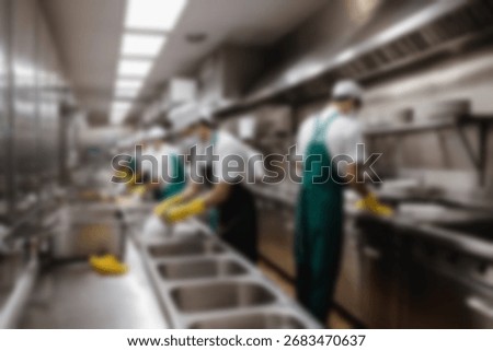 Blurred background a restaurant kitchen worker is working washing dishes after being used by customers.