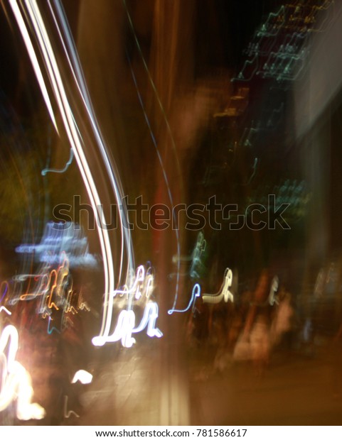 Blurred background with road lamp, car light,\
sign and traffic lighting at night\
time.