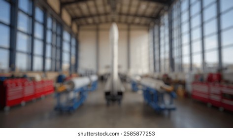 Blurred background of rocket prototype in modern workshop surrounded by tools and equipment, showcasing advanced engineering in aerospace development and innovation