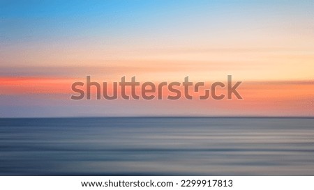 Blurred background of the sea in the evening hours after sunset, horizontal motion blur.