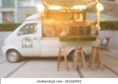 blurred background of side view mini van food trucks with orange filter and warm sunlight filter for business start up concept.