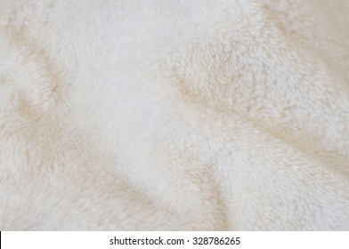 Blurred background of soft light tissue. Beige background of plush fabric