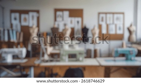 Blurred background of spacious and creative sewing studio featuring multiple sewing machines, dress forms, fabric rolls, and fashion illustrations on display in a bright room