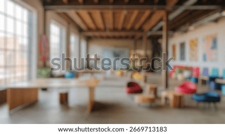 Blurred background of spacious creative workspace designed with unique wooden furniture and vibrant seating, showcasing a blend of art and comfort in an industrial setting.