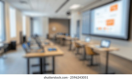 Blurred background of a spacious modern classroom features sleek desks equipped with laptops, fostering a dynamic learning environment with a large screen display for presentations and data sharing. - Powered by Shutterstock - Get 15% off with code: PIKWIZARD15