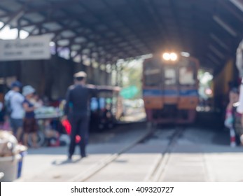 Blurred background, station master and train in Maeklong market