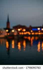 Blurred background of Stockholm city at night. Cityscape lights captured with reflection on the river.