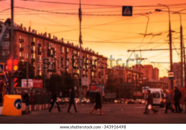 Blurred background: street with road, cars,\
pedestrian, crosswalk, traffic lights, signs etc on the sunset in\
Moscow, Russia. Image with\
toning