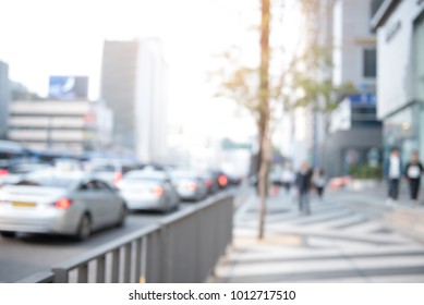 Blurred Background Of Traffic Jam On The Road And People Walking On Sidewalk In City.