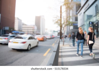 Blurred Background Of Traffic On The Road And People Walking On Sidewalk In City, Perspective.