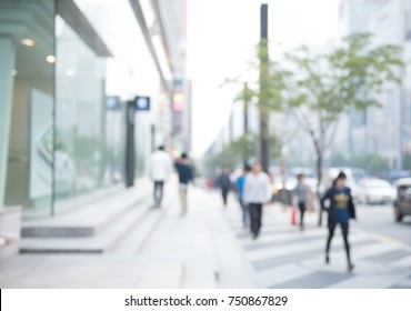 Blurred background of traffic on the road and people walking on sidewalk, business area in city, Seoul Korea, perspective.
