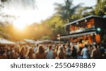 Blurred background of a vibrant outdoor music festival in brazil showcasing a lively crowd enjoying the performance under the warm sunset glow, surrounded by palm trees.