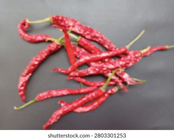 Blurred background view of dried red chili peppers on black surface