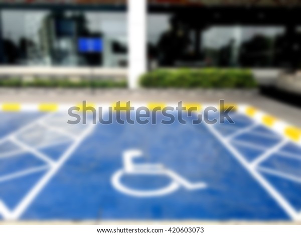 Blurred\
background wheel chair symbol in parking\
lot