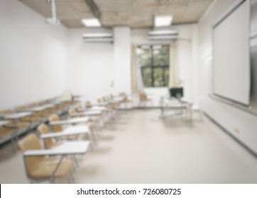 Blurred Background White Lecture Room With Equipments, Teacher Desk, Overhead Projector, Screen And Lecture Chairs For Students  Nobody No Class Time