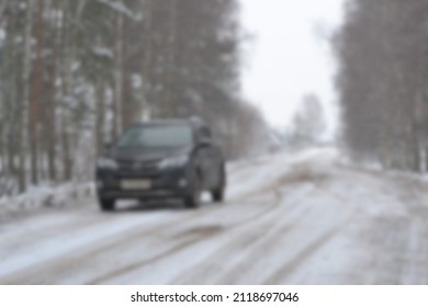 Blurred Background Of A Winter Country Road, A Black SUV Is Moving Along It, Traveling On The Road In Snow.