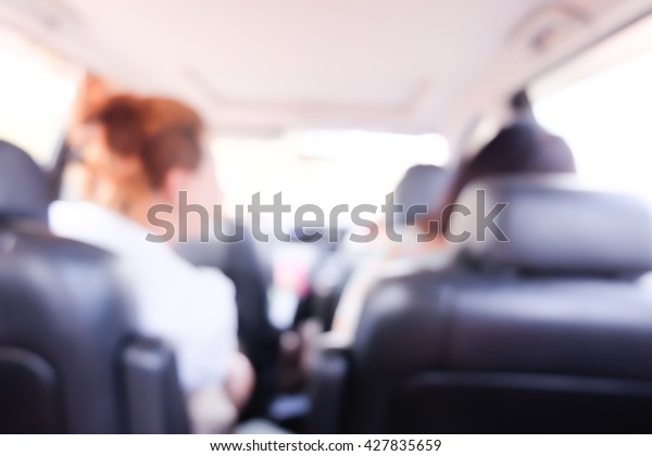 Blurred \
background of women with friend in\
car.