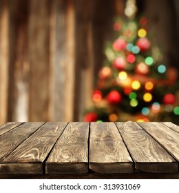 Blurred Background Of Xmas Tree Lights And Wall With Table Of Brown Color 