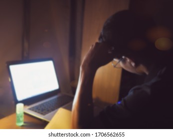 The Blurred Background Of The Young Man Pondering The Concept Of Working At Home, Online Education, Abstraction, Night Scenes As Per The Policy Prohibiting Leaving The House During The Given Period.  