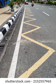 blurred background, zig zag line mean motorcycle  parking area. it's side of the road city.