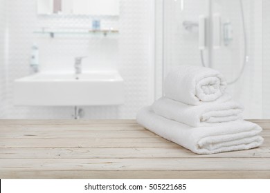 Blurred bathroom interior background and white spa towels on wood - Powered by Shutterstock