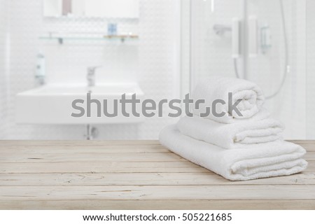 Blurred bathroom interior background and white spa towels on wood