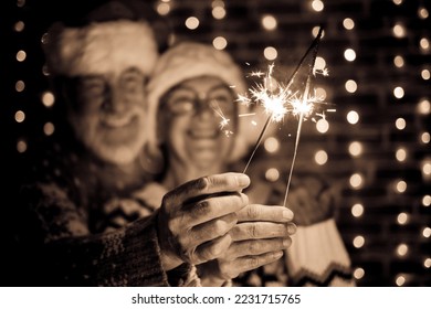 Blurred black and white portrait of senior couple in Santa hat holding sparkle light. Celebration Xmas, new year concept - Shutterstock ID 2231715765