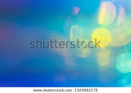 Blurred blue and green abstract lens flare background. Defocused glow effect. Illuminated bokeh