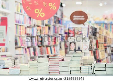 Blurred bookshelves of bookstore with colorful books, glass showcase. Education, school, study, reading fiction concept. Abstract background