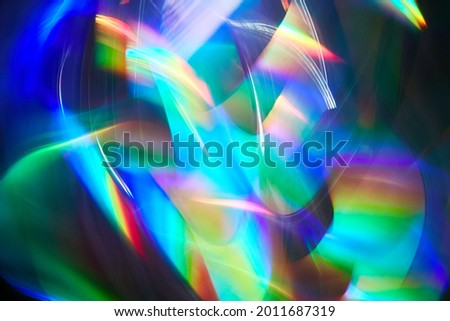 Blurred bright rainbow light. Lens or prism dynamic flare. Draving shiny spots. Dark background. Illuminated burst of multicolor light.