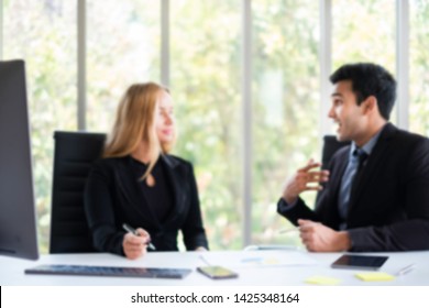 Blurred Business People Having Business Talk In Office. The Successful Gay Man Working Together As A Team In Company. The Discussion Is About  E-commerce & Online Technology. LGBT And Gay Concept.