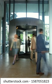 Blurred Business People In Revolving Door Of Lobby