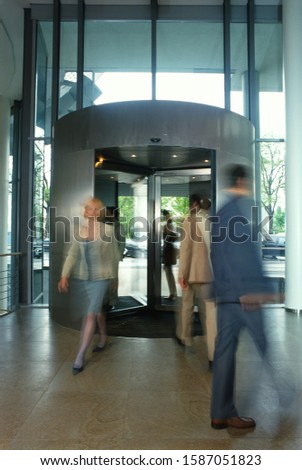 Blurred business people in revolving door of lobby