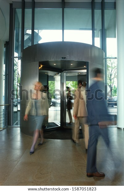 Blurred\
business people in revolving door of\
lobby