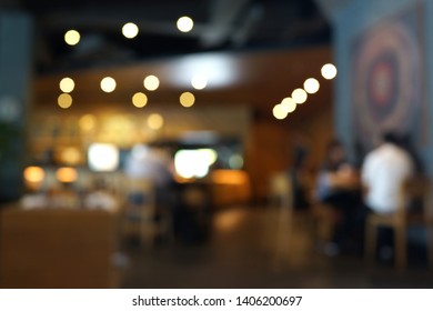 Blurred Cafe Interior With Some People On A Background. Coffee House Blur Background.