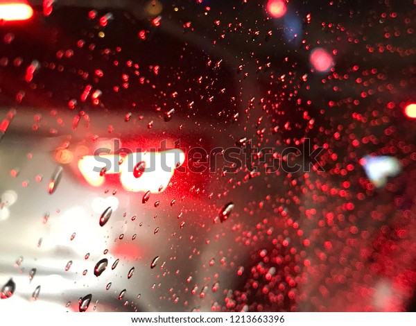 Blurred car brake light in\
the rain