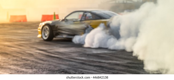 Blurred car drifting on asphalt racing track with lot of smoke, motion blur drift car.
